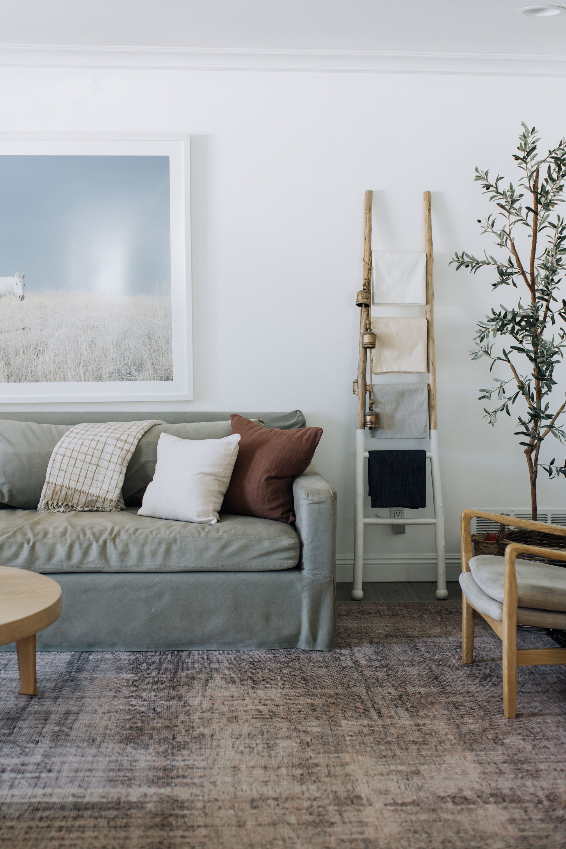 Beach-inspired living room with gray sofa, wooden coffee table, and Tierra's 100% linen accent pillows in white and brown colors creating a relaxed lived-in coastal aesthetic.