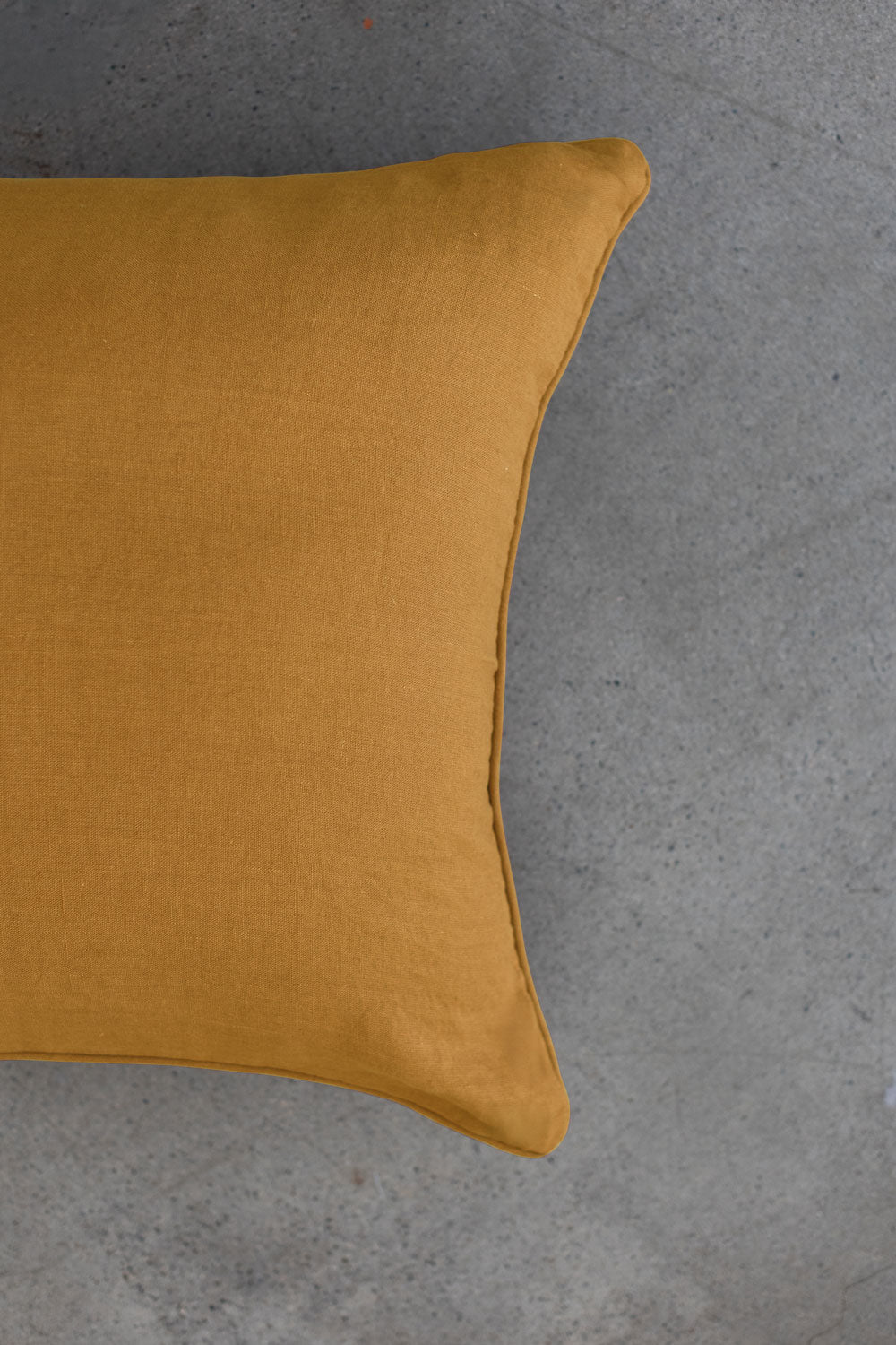 The scene highlights Tierra’s 100% Linen Headboard Cushion Cover through a series of soft, neutral bedroom scenes. It shows a smooth yellow pillow resting against a muted backdrop, emphasizing the clean, breathable feel of natural linen. 