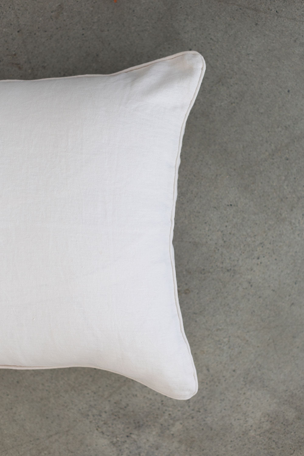 The scene highlights Tierra’s 100% Linen Headboard Cushion Cover through a series of soft, neutral bedroom scenes. It shows a smooth white pillow resting against a muted backdrop, emphasizing the clean, breathable feel of natural linen. 