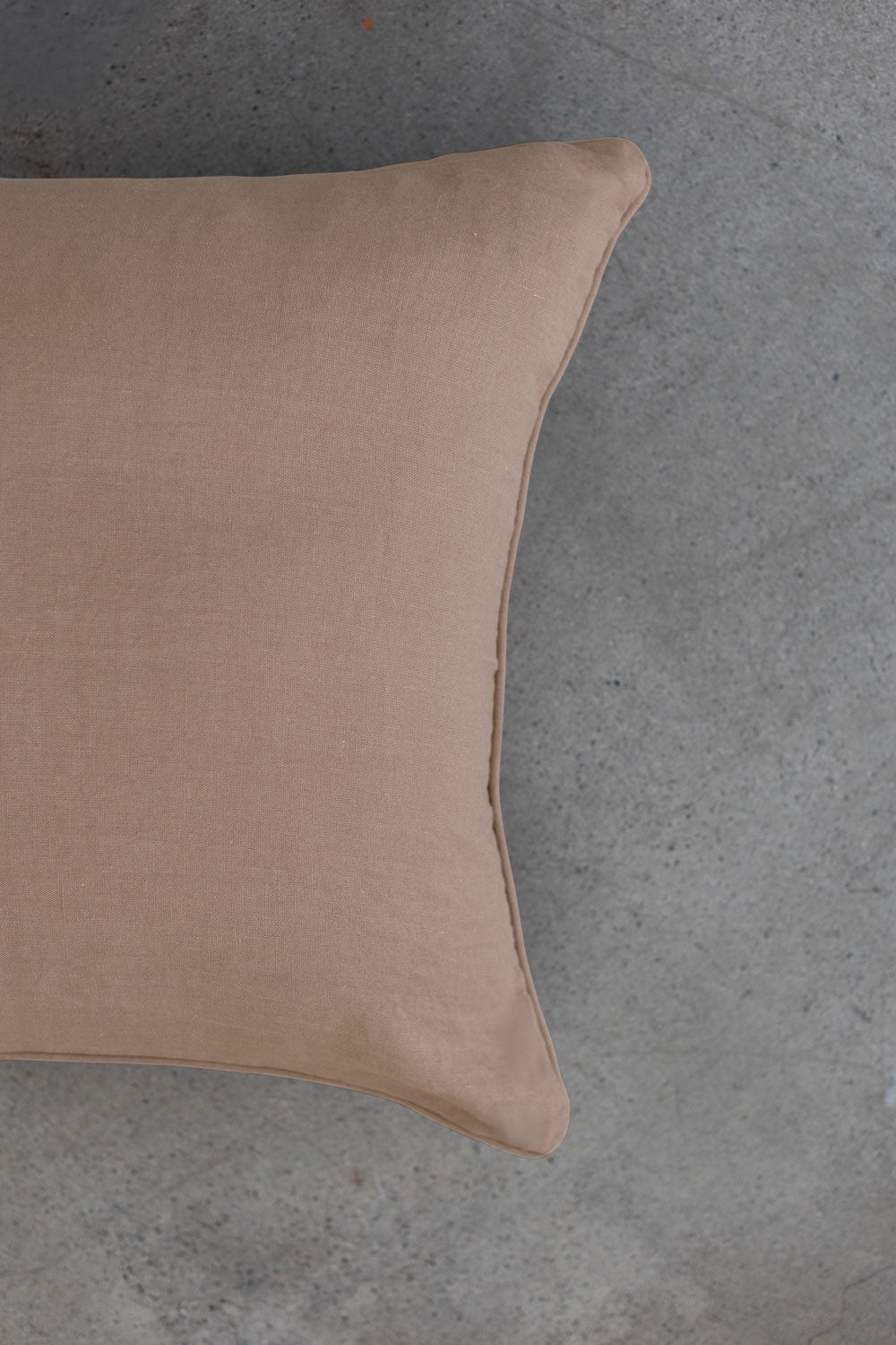 The scene highlights Tierra’s 100% Linen Headboard Cushion Cover through a series of soft, neutral bedroom scenes. It shows a smooth beige pillow resting against a muted backdrop, emphasizing the clean, breathable feel of natural linen. 