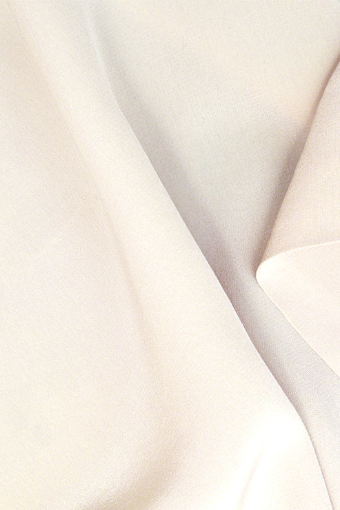 The photo offers a close-up of smooth, gently folded fabric, highlighting the clean weave, breathable texture, and irresistibly soft hand‑feel of 100% organic cotton. 